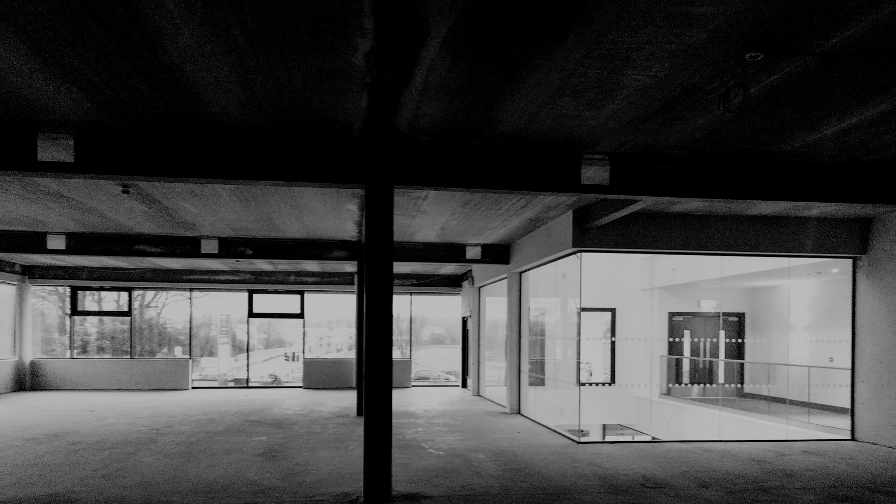 Commercial interior with glass walls and concrete beams